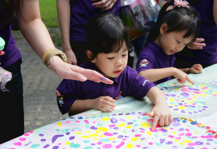 小孩子用心製作色彩繽紛的手指畫